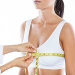 Doctor with measure tape measuring the size of the patient's bre
