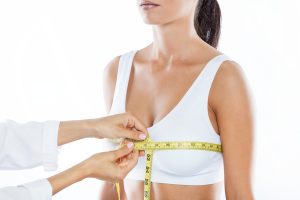 Doctor with measure tape measuring the size of the patient's bre